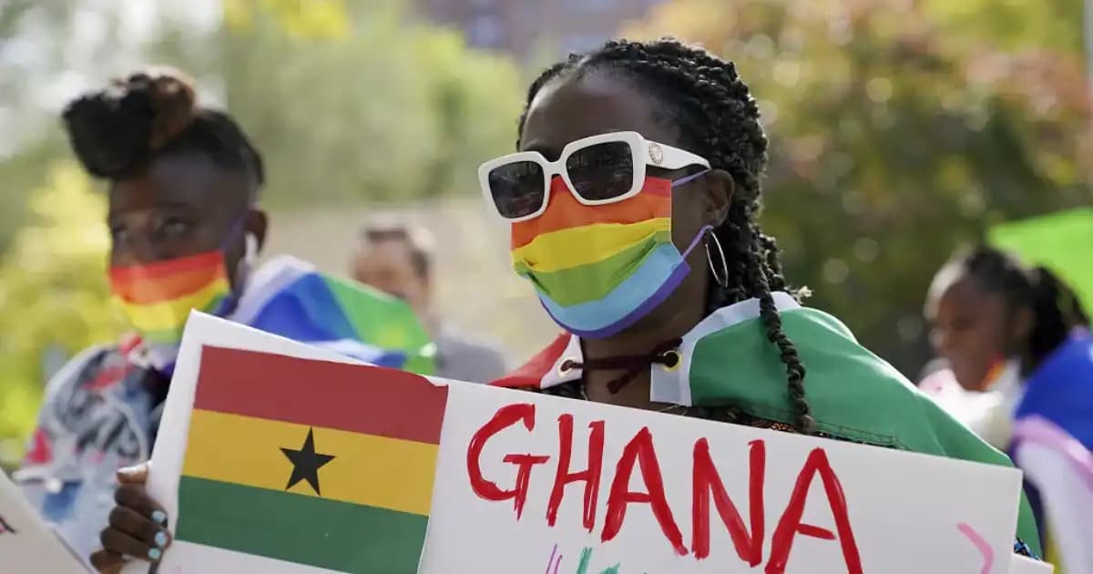 Manifestation pour les droits LGBT au Ghana, pancartes et drapeaux colorés en arrière-plan.